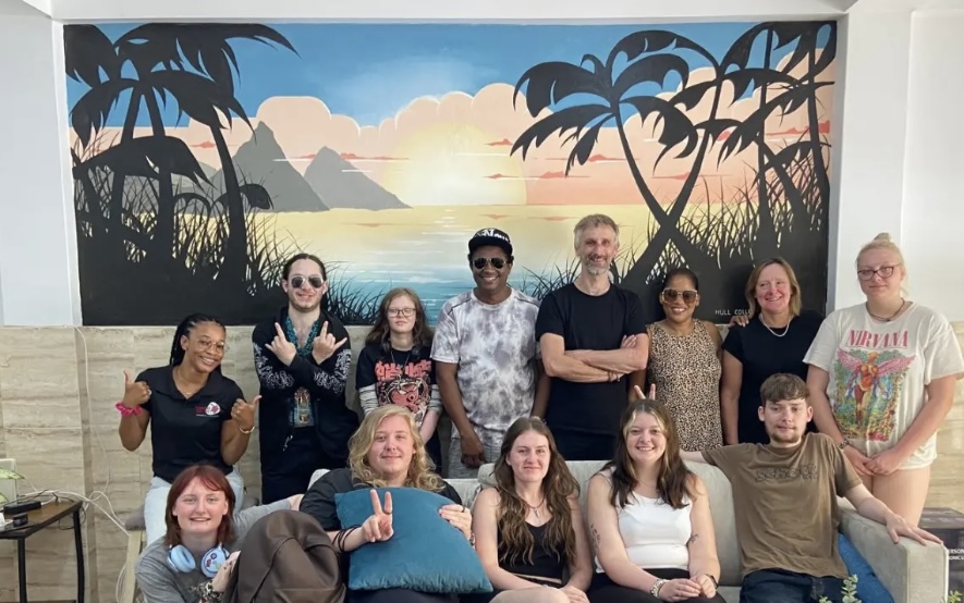 Mural group in front of a coastal sunset wall painting with palm trees