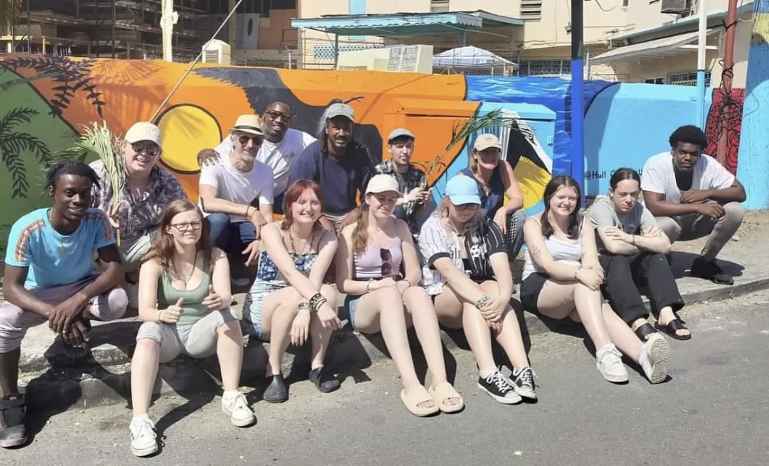Mural group in front of a colourful outdoor tropical landscape painting